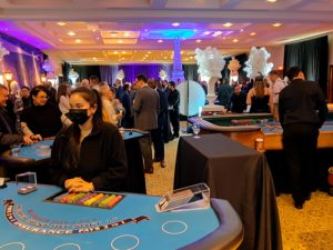 Casino fundraiser with guests actively playing at casino tables.