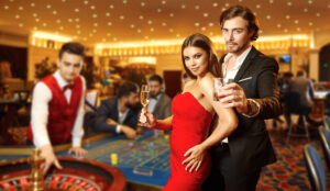 Man and woman standing at a casino table with drinks in hand
