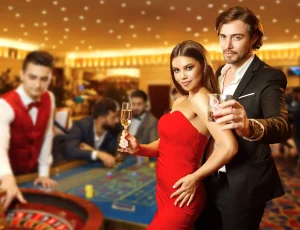 Man and woman standing at a casino table with drinks in hand